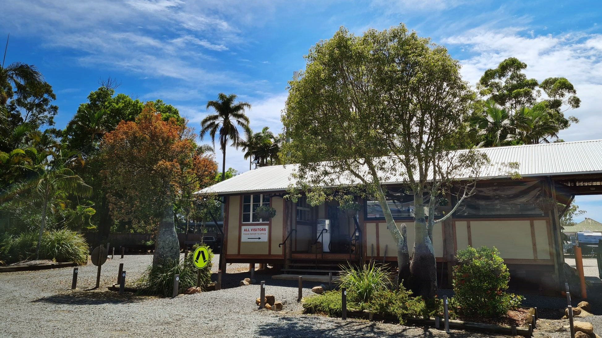 The Driving Wheels Roadhouse - a lowset building with gardens and a gravel driveway on a sunny day